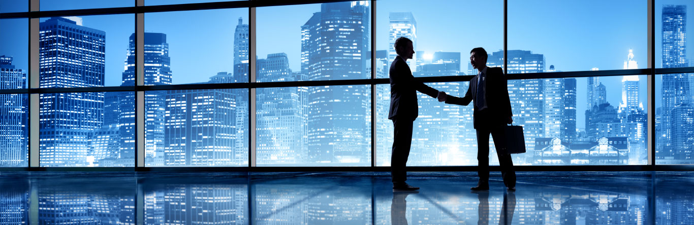 two men shaking hands with city skyline behind